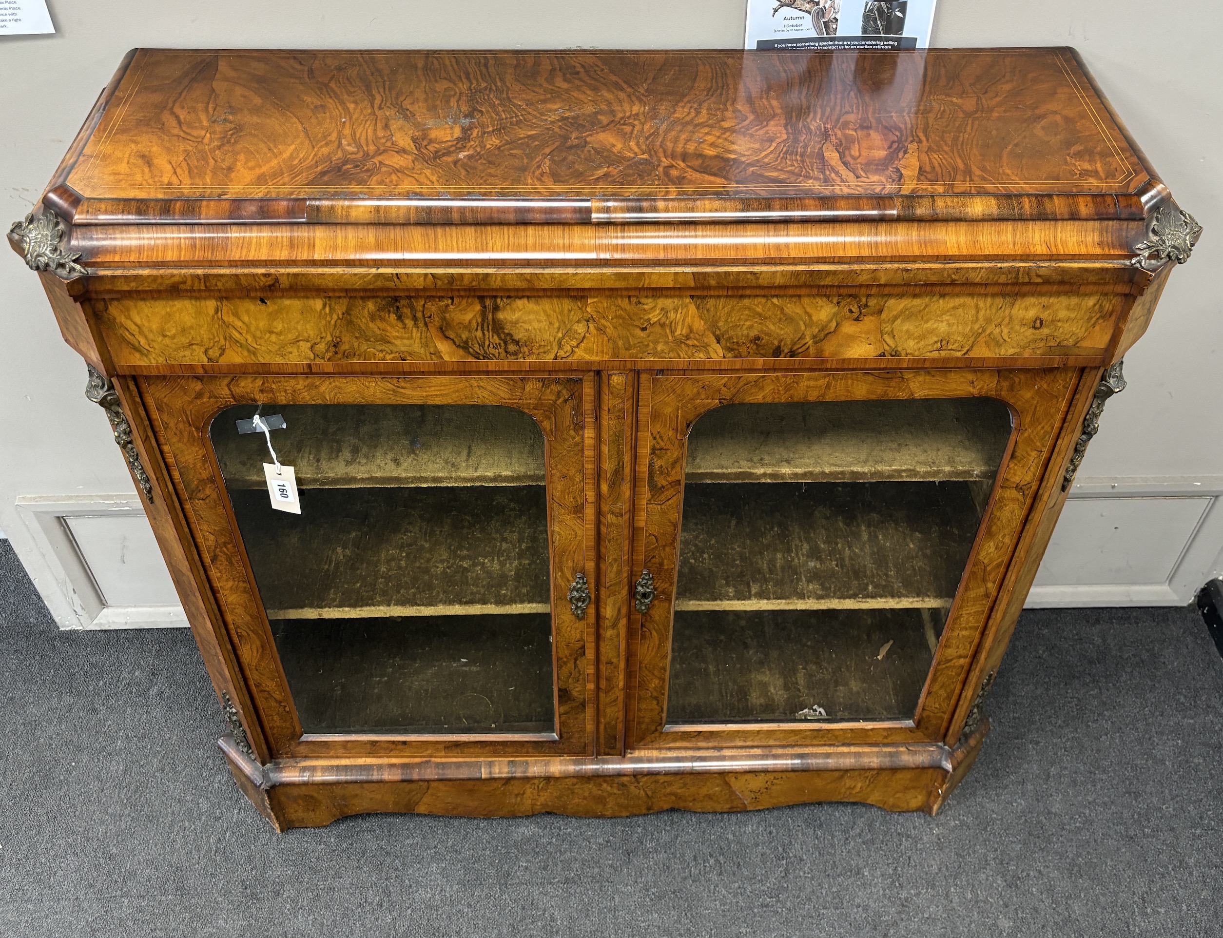 A mid Victorian tulip banded and gilt metal mounted figured walnut two door glazed side cabinet, width 114cm, depth 35cm, height 109cm.